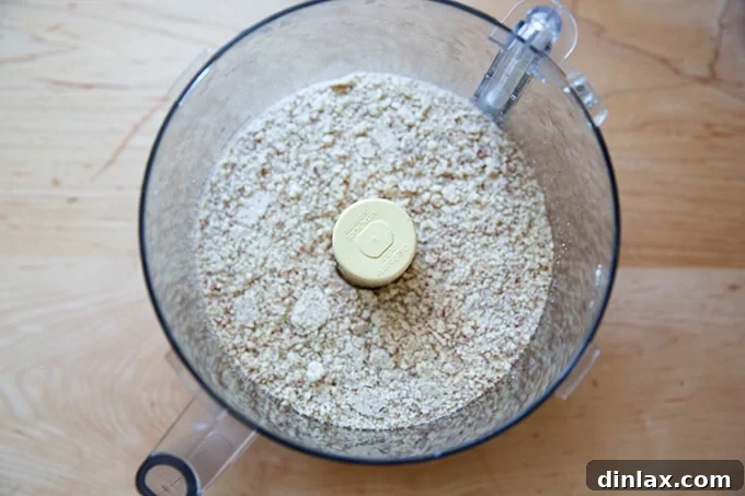 Classic Caprese Flourless Chocolate Almond Torte 4 A food processor bowl containing finely ground almonds mixed with sugar, ready for incorporation into the batter.