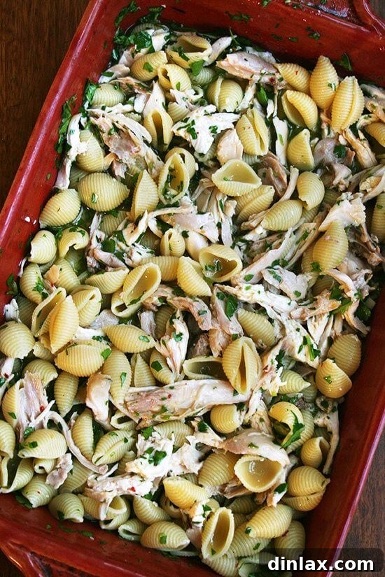 Make-Ahead Lemon & White Wine Chicken Pasta 2 A 9x13-inch pan filled with pasta, chicken, herbs, lemon, and white wine, ready to be served.