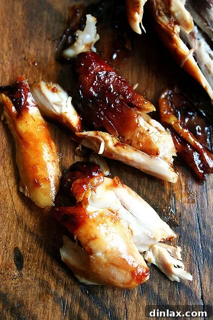 Sticky Honey-Soy Chicken 9 A perfectly cooked honey-soy chicken drumstick, cut open on a cutting board, revealing its succulent interior.