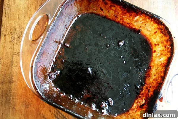 Sticky Honey-Soy Chicken 10 A soiled, empty cooking pan after baking chicken, needing a thorough scrub for cleanup.