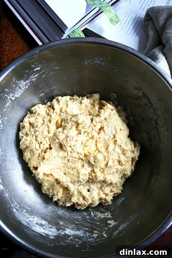 The freshly mixed pastry dough in a large bowl, covered with plastic wrap, ready to be chilled in the refrigerator.