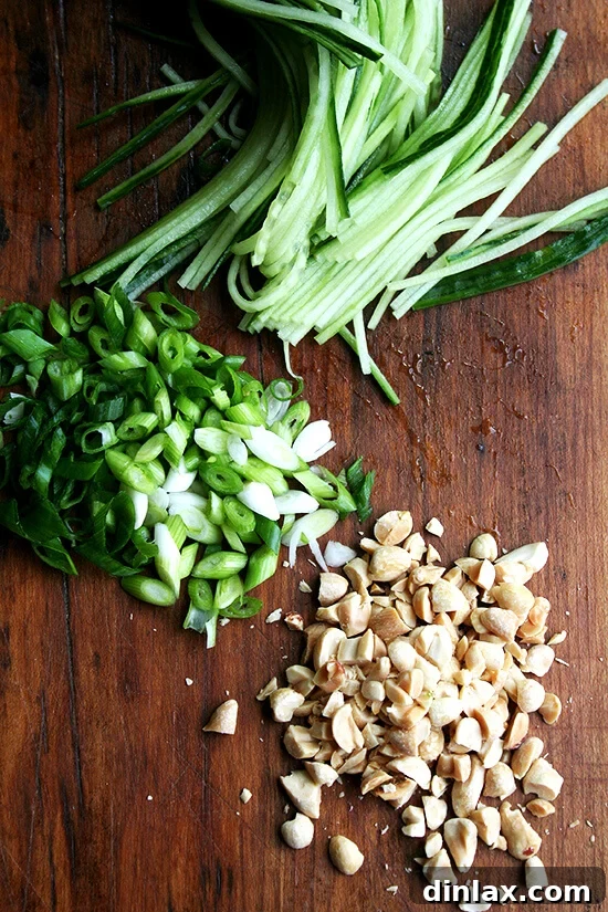 Freshly sliced cucumbers, chopped scallions, and roasted peanuts for soba salad
