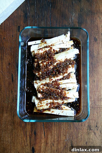 Close-up of marinated tofu soaking in ginger garlic soy dressing, absorbing rich flavors for the soba noodle salad.