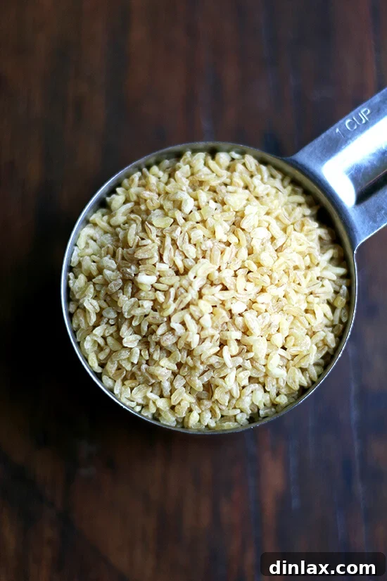 A cup filled with dry bulgur grains, showing the measurement before soaking.