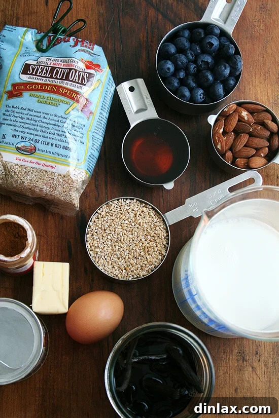 Wholesome Baked Steel Cut Oats 3 The organized ingredients for baked steel cut oatmeal: steel cut oats, maple syrup, butter, egg, vanilla extract, cinnamon, baking powder, milk, almonds, and an optional bowl of fresh berries.