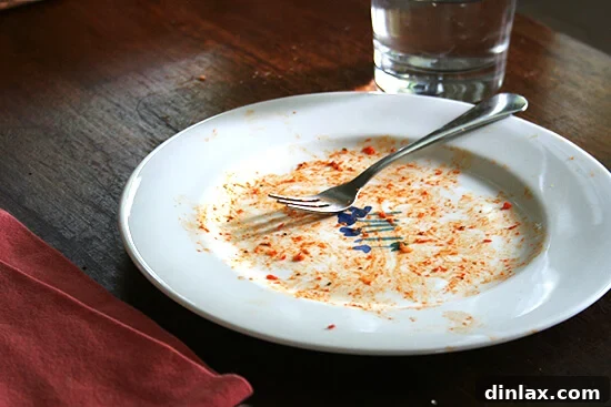 A serving of pasta shells generously coated in the rich red pepper tomato sauce, ready to enjoy.