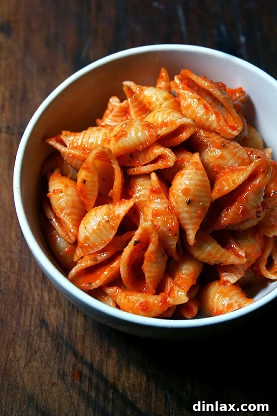 Close-up of pasta shells with red pepper tomato sauce, garnished and ready for serving.