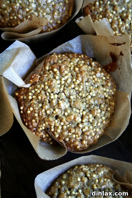 Wholesome Millet Muffins 2 A golden-brown millet muffin on a wooden board, showcasing its delightful seedy texture.