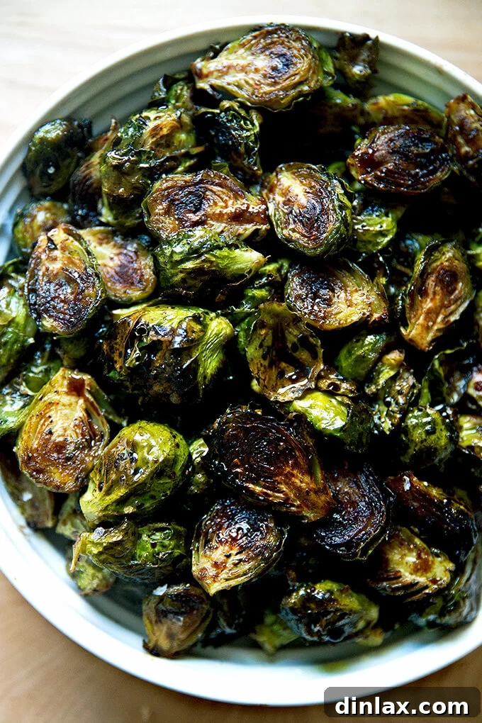 A beautiful white serving bowl filled with glossy, balsamic-roasted Brussels sprouts, ready to be enjoyed.