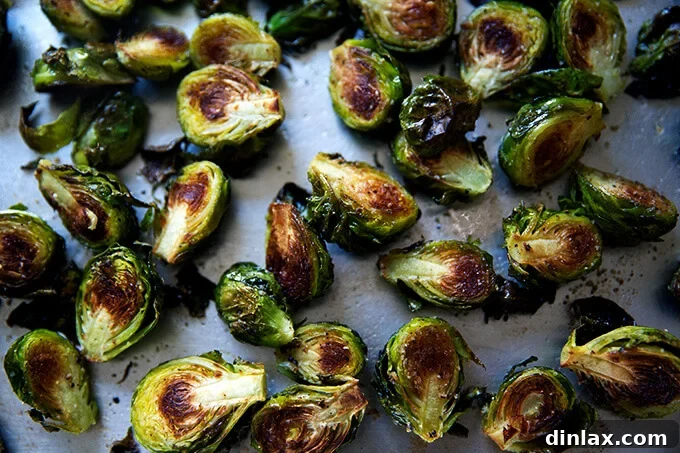 A sheet pan showcasing perfectly roasted Brussels sprouts, golden-brown and slightly crispy, fresh out of the oven.
