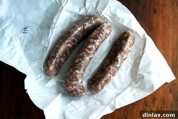 Several links of raw hot Italian sausage, a key ingredient for a flavorful broth.