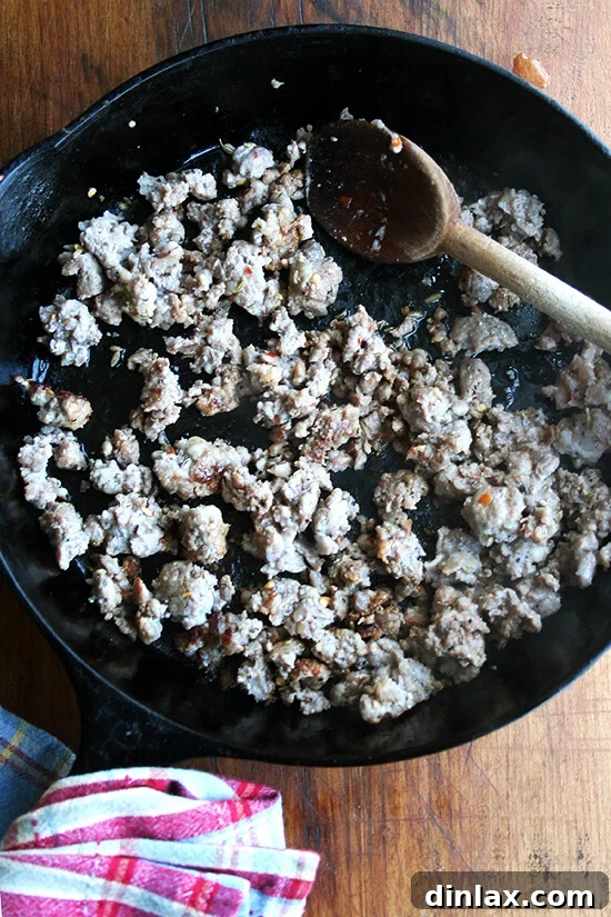 Hearty Italian Sausage, Escarole, and White Bean Soup 13 Hot Italian sausage browning in a cast iron skillet, releasing its rich aromas and fat.