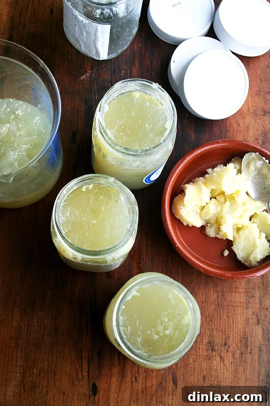 Hearty Italian Sausage, Escarole, and White Bean Soup 6 An overhead view of several jars of homemade chicken stock, with a separate bowl of solidified fat carefully scraped from the cooled stock.