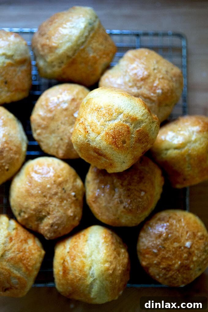 Freshly baked thyme dinner rolls cooling on a wire rack.