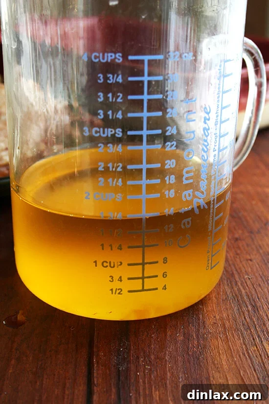 A liquid measuring cup clearly showing 1.75 cups of rendered duck fat and melted butter, a valuable byproduct ready for storage and reuse.