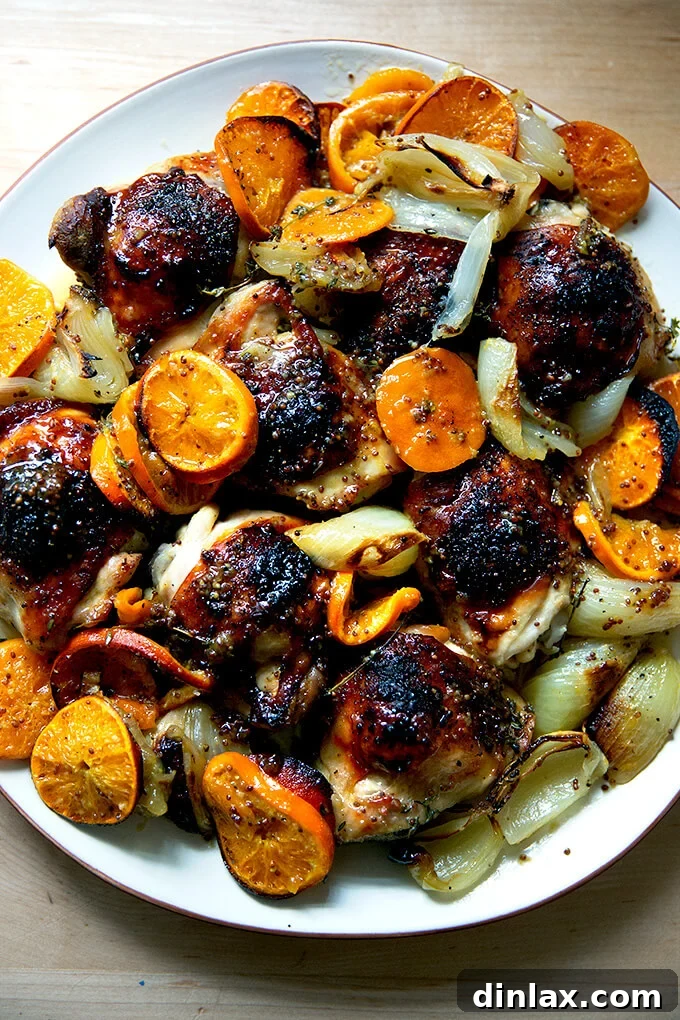 Clementine-Kissed Roast Chicken 2 A platter of roast chicken and clementines, beautifully browned and garnished.