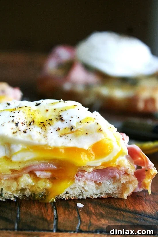 Croque Madame — croque monsieur topped with a poached egg — on a cutting board.