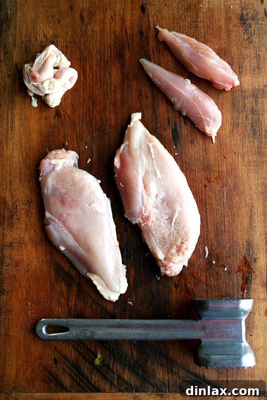 Raw chicken breasts and tenders, prepared for light pounding before cooking.