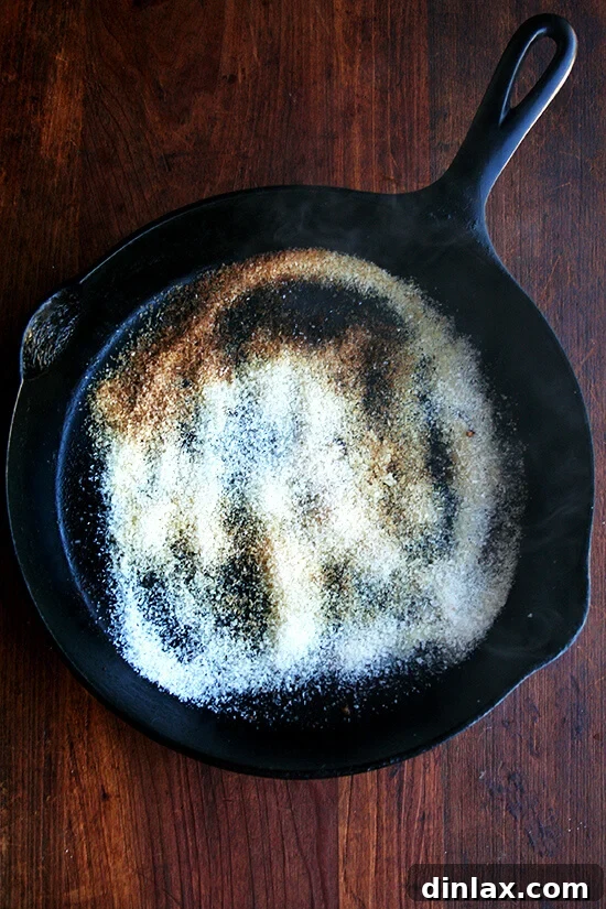 Adding kosher salt to a cast iron pan for gentle cleaning.