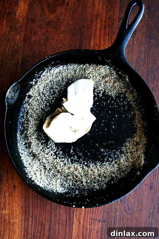 Wiping out a cast iron pan with salt and oil for proper cleaning and seasoning.