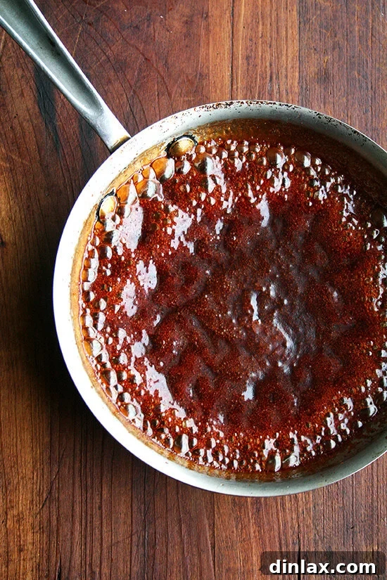 Teriyaki sauce reducing further on the stovetop to achieve optimal thickness.