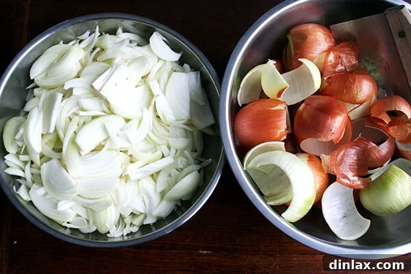 Two large bowls, one containing sliced onions and the other filled with onion peels and scraps.