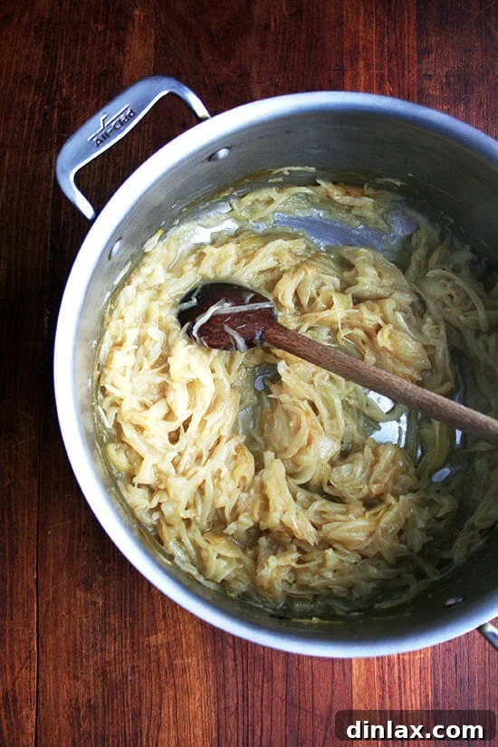 Onions, after two hours of slow stewing uncovered in a large pot, showing early signs of caramelization.