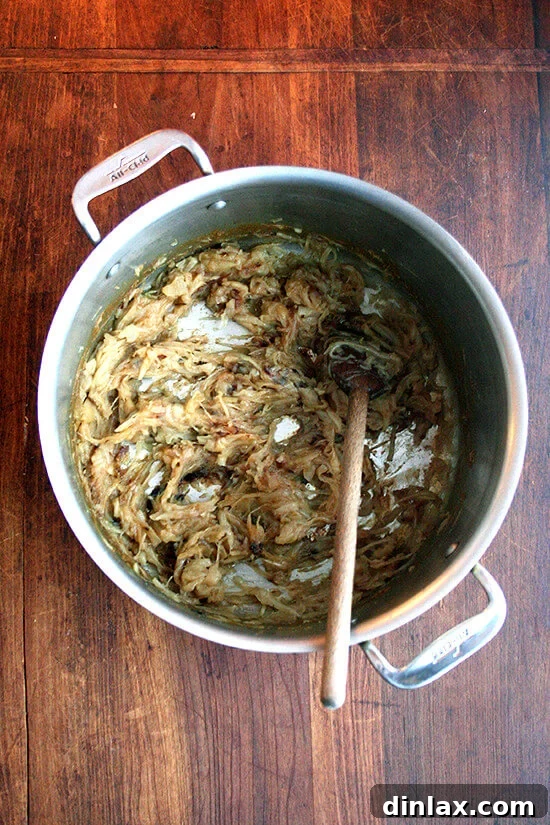 Onions, deeply caramelized to a rich amber color after 3.5 hours of slow stewing in a large pot.