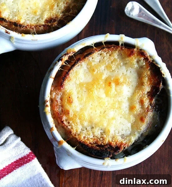 Two bowls of French Onion Soup with perfectly melted cheese and golden bread.