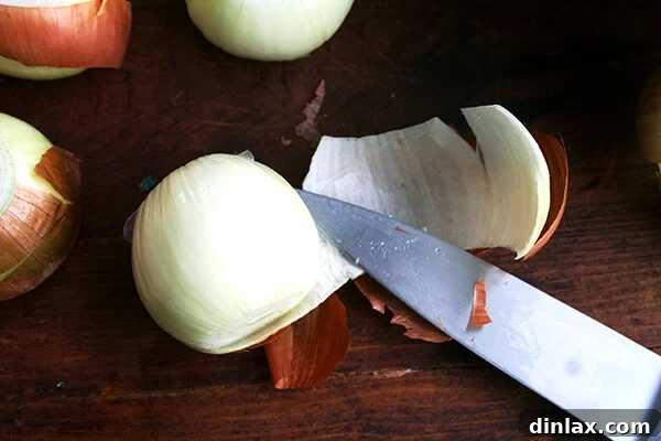A perfectly peeled onion resting on a cutting board.