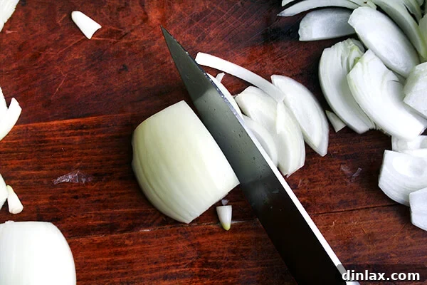 A thinly sliced onion on a cutting board.