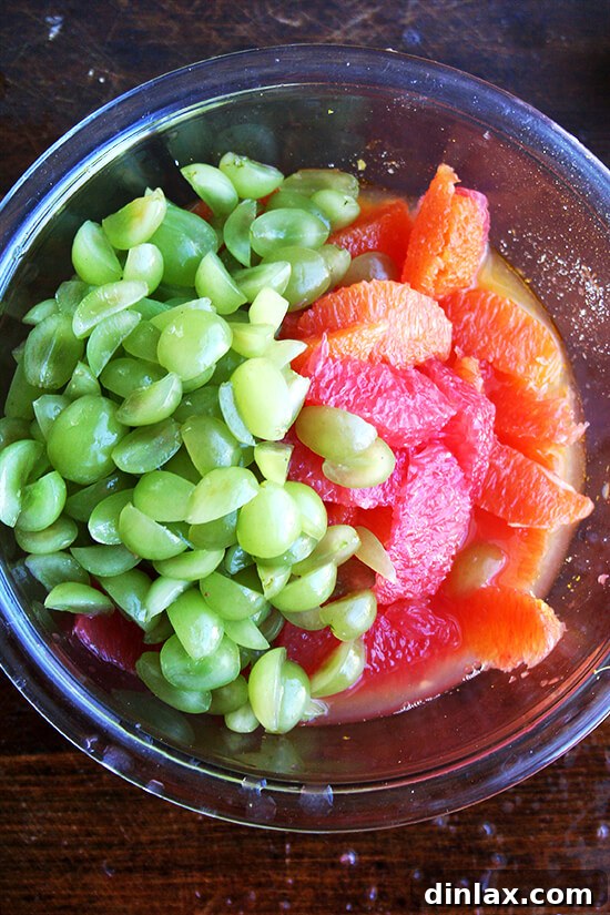 Bright Citrus and Green Grape Compote 5 The compote ingredients being gently mixed in a large bowl, highlighting the vibrant colors and textures.