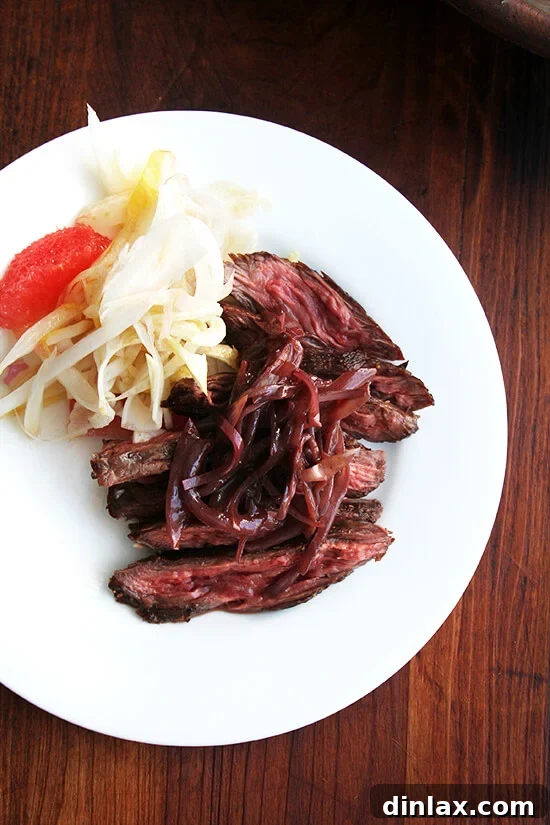 Close-up of seared skirt steak topped with rich shallot compote, a perfect and enticing meal.