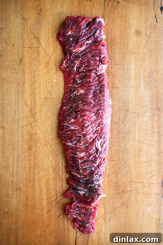 Long skirt steak prepared for cutting, highlighting its unique shape.
