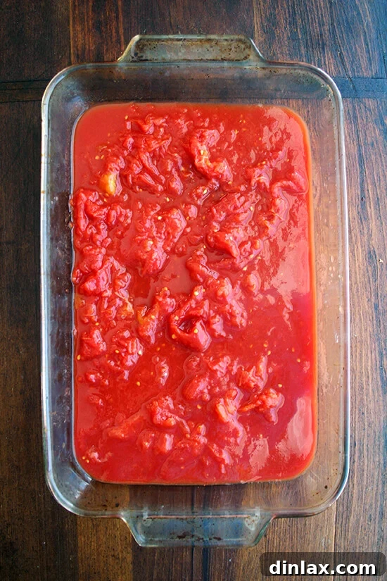 Crushed canned tomatoes in a baking dish, showcasing their texture.
