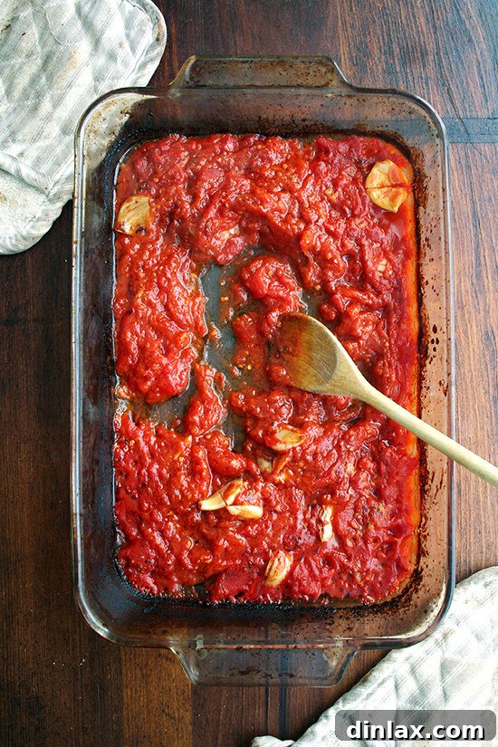 The finished roasted tomato sauce, showcasing its thick, jammy texture after being mashed.