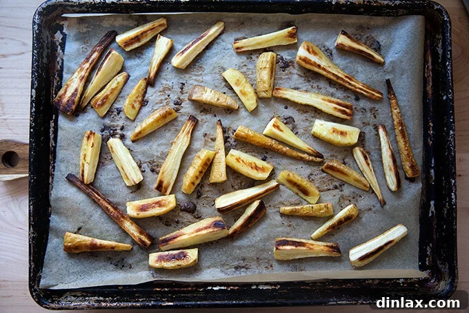 Roasted Chili-Honey Parsnips 6 A sheet pan filled with beautifully roasted parsnips, golden brown and tender, with caramelized edges, fresh out of the oven and emanating a delicious aroma.