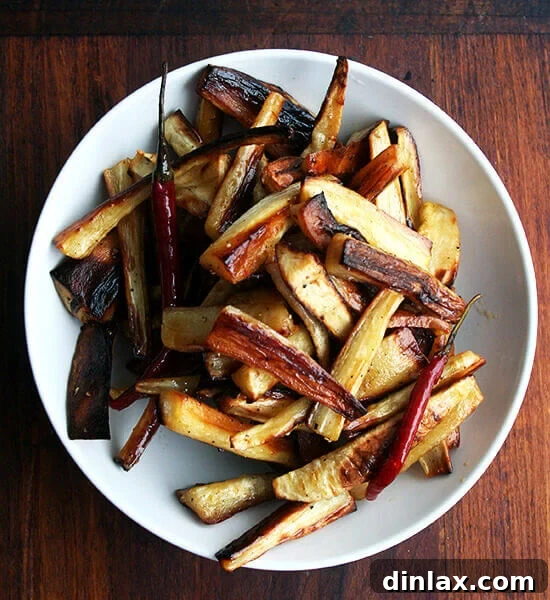 A close-up of beautifully roasted parsnips coated in spicy honey butter in a rustic serving bowl, ready to be enjoyed.