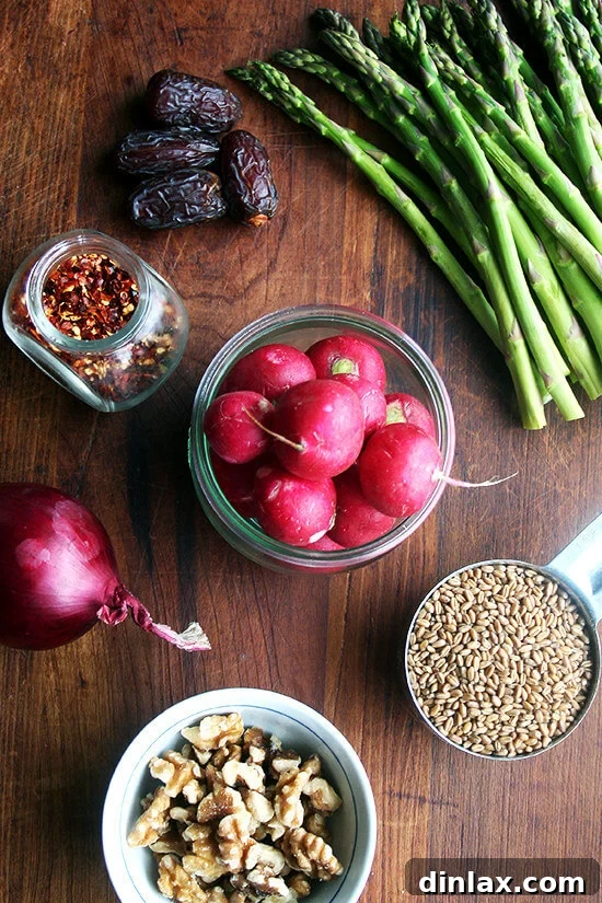 Vibrant Spring Wheat Berry Salad 2 Fresh ingredients for spring wheat berry salad laid out on a cutting board, including wheat berries, asparagus, radishes, and walnuts.