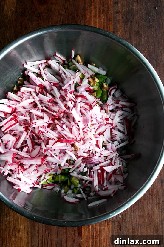 Vibrant Spring Wheat Berry Salad 6 Various prepped ingredients for the spring wheat berry salad, including chopped walnuts, dates, and macerated red onion, in a large mixing bowl.