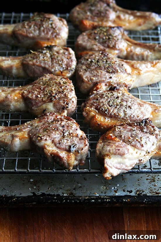 Broiled lamb chops resting on a pan after cooking, showcasing their perfectly seared exterior.