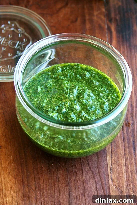 Nigella Lawson's mint sauce stored in a glass jar, ready for serving or refrigeration.