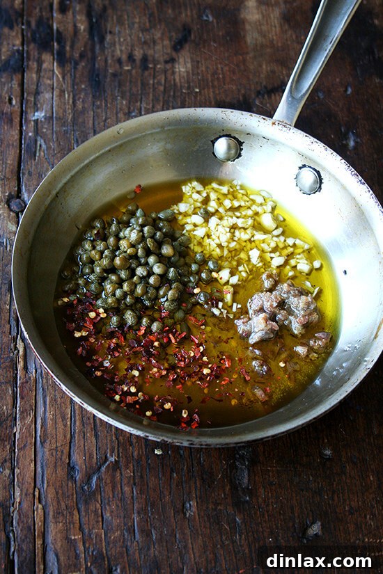 Campanelle Primavera with Eggs, Capers, and Watercress 2 Essential ingredients for the campanelle dish: capers, anchovies, fresh garlic, and red pepper flakes, ready to create a rich and savory sauce.