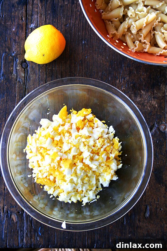 Campanelle Primavera with Eggs, Capers, and Watercress 3 Key components for the pasta: vibrant lemon, golden hard-boiled eggs, and uncooked campanelle pasta, promising a delightful texture and flavor.