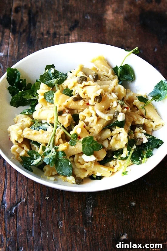 The finished campanelle pasta dish, beautifully plated with hard-boiled eggs, capers, anchovy sauce, and fresh watercress, ready to be enjoyed as a delightful, quick dinner.
