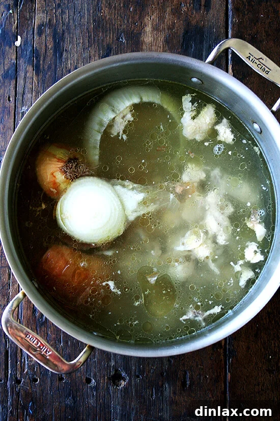 Spicy Smoky Chicken Tinga Tacos 9 A large stock pot brimming with chicken carcass and onion scraps, simmering to create rich homemade chicken stock.