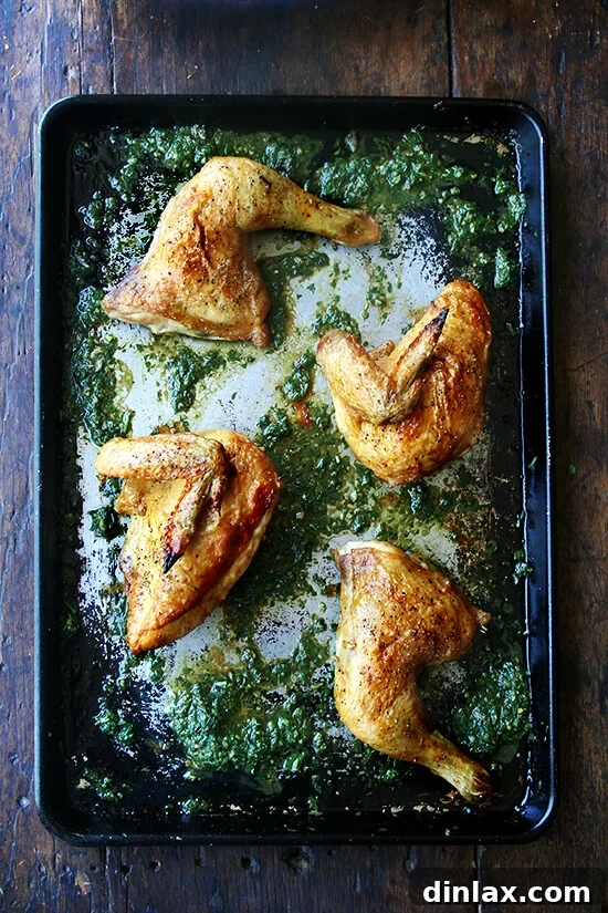 A beautifully roasted chicken piece, its skin golden and crisp, resting on a bed of rich, aromatic herb sauce, with pan juices mingling. It is ready to be served.