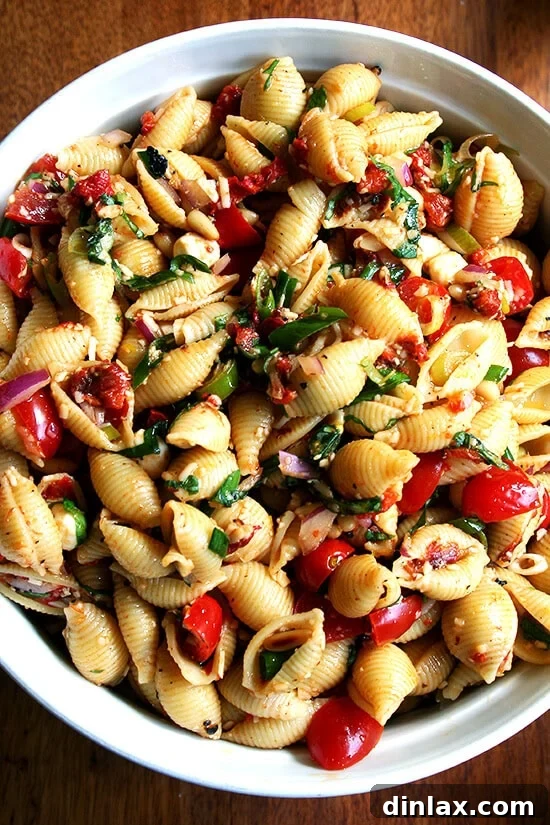 A vibrant and simple pasta salad, perfect served warm or at room temperature, featuring pasta shells, melting mozzarella, fresh tomatoes, and a zesty lemon-olive oil dressing. Ideal for potlucks and family meals, and it tastes even better when made ahead.