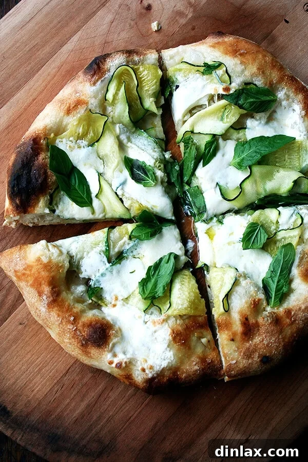 This Zucchini Anchovy Pizza, marrying the delicate salinity of anchovy with melting summer squash and creamy burrata, is crowned with fresh basil. It's an ideal dish for entertaining friends and creating unforgettable memories. A recipe to savor from alexandracooks.com A stunning Zucchini, Burrata, and Anchovy pizza, generously adorned with fresh basil leaves, showcasing a perfect golden crust and melted cheese.