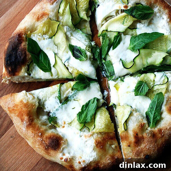 The Zucchini Anchovy Pizza, a vibrant summer dish with melted burrata and fresh basil.